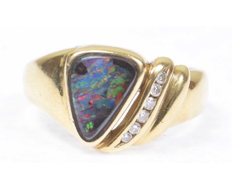 A black opal and diamond ringThe triangular shape black opal highlighted by a row of round brilliant-cut diamonds, stamped 75