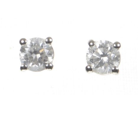 A pair of diamond ear studsEach round brilliant-cut diamond, four claw set, mounted in platinum, with ear posts and butterfly