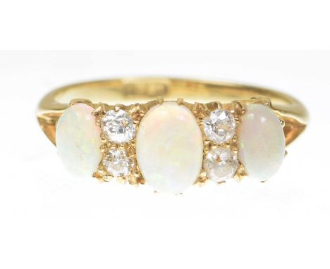 An early 20th century opal and diamond three stone ringThe oval cabochon opals interspersed by four old-cut diamonds, shank s