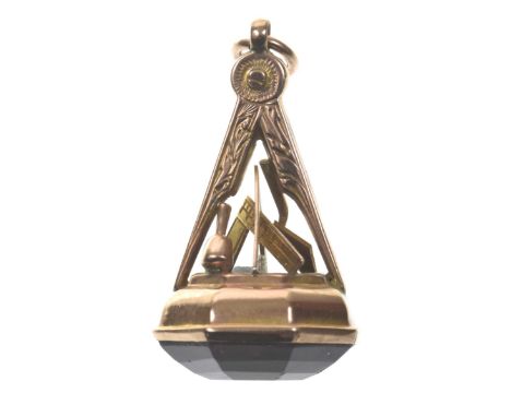 A Masonic fobThe octagonal purple stone to the Masonic compass and square motif, in umared precious yellow metal, length 3.5c