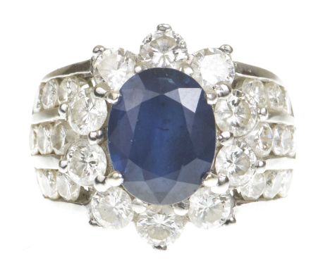 A sapphire and diamond cocktail ringCentering an oval shape sapphire within a round brilliant-cut diamond surround, flanked b