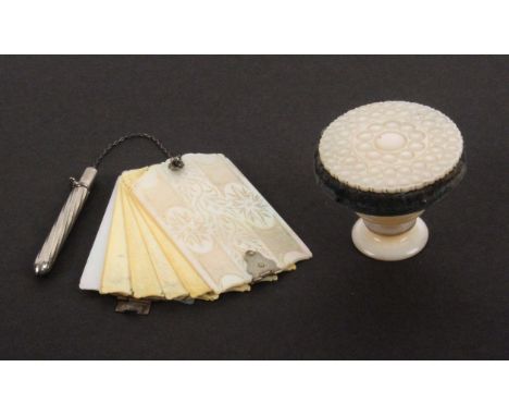 A mother of pearl standing pin cushion and a similar swivel notelet, the first in the form of a miniature table, the top with