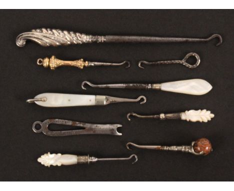 Nine button hooks, comprising an example with 9ct gold handle, Birmingham 1899, 7.2cms, a silver example hinging into a mothe