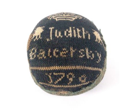A dated late 18th Century pin ball, one side inscribed in white on dark green 'Judith Battersby 1790', below a crown and flan