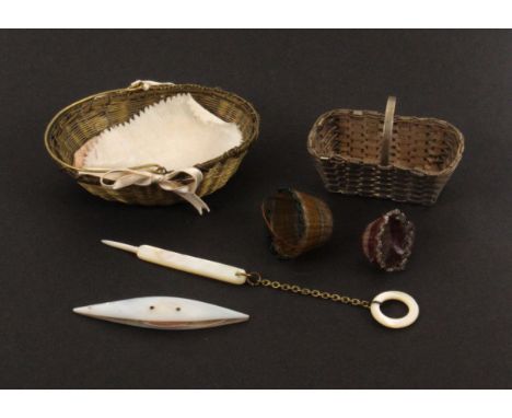 A gilt metal netting basket and three other miniature baskets, the first in woven brass with swing handle and containing a mo