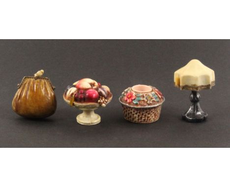 Three celluloid novelty tape measures, and a thimble holder, the tape measures comprising a tazza of fruit, 5cms dia., a tabl