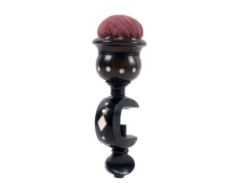 An unusual mid 19th Century horn and mother of pearl inlaid sewing clamp, the 'C' shaped frame below a vase form pin cushion 
