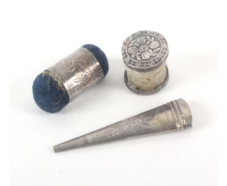 Three silver sewing tools, comprising a silver girdle form double ended pin cushion with floral decoration, 3.5cms, a Georgia