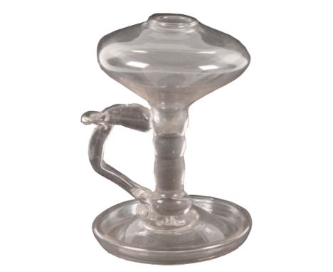 An early 19th Century lace maker's glass lamp, the bowl on a knopped stem with scroll handle and thumb piece on a circular ba