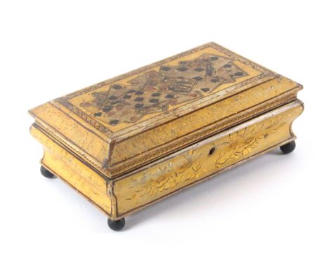 A Regency yellow ground playing card box, the serpentine sides decorated in gilt and black with leaves and flowers, the cante
