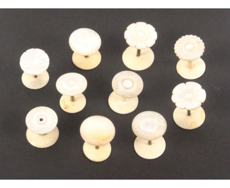 Ten mother of pearl top reel holders, with brass or bone stems to bone bases, including a pair, largest 3.5cms high.      (10
