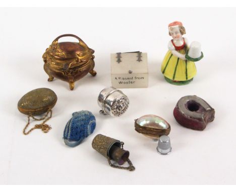 Nine various thimble boxes and stands, comprising an early 20th Century continental porcelain example of a young girl, 7.5cms