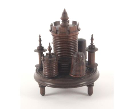 A mid 19th Century rosewood turret form sewing companion, the turned circular base on three turned feet and mounted with thre