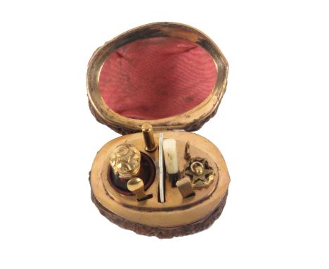 An unusual natural walnut etui for a child or doll, hinged gilt metal mount with unusual fittings comprising a ruby glass sce