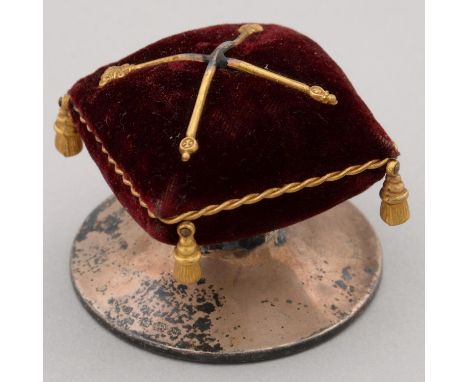 NEEDLEWORK TOOLS. A GEORGE V COMMEMORATIVE SILVER MAROON VELVET AND GILT TASSELED PIN CUSHION, 45MM H, BY HENRY WILLIAMSON LI