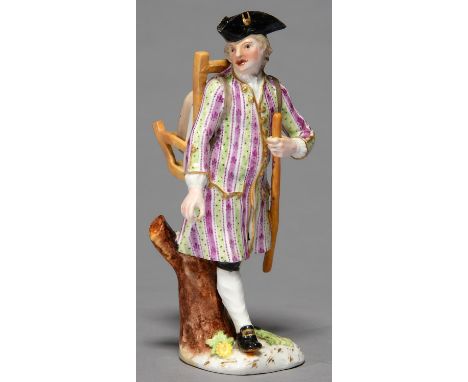 A GERMAN FIGURE OF A PEDLAR, 19TH C, CARRYING A PACK IN A SCARF, IN PUCE AND GREEN STRIPED COAT AND BLACK BREECHES, 19CM H ST