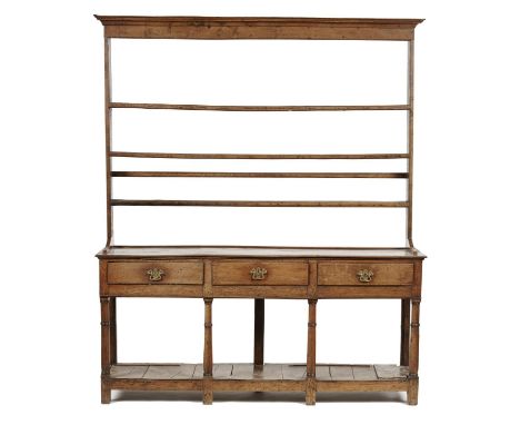 A GEORGE III OAK DRESSER, EARLY 19TH C, THE LOFTY RACK WITH CAVETTO CORNICE AND THREE MOULDED SHELVES, THE BASE FITTED THREE 