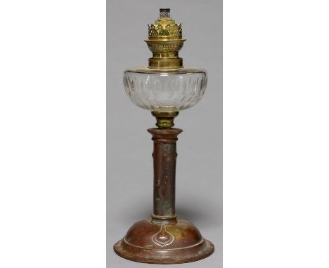 AN ART NOUVEAU OIL LAMP, C1910, WITH CUT GLASS FOUNT AND BRASS BURNER, THE DOMED FOOT EMBOSSED WITH THREE SEED PODS, 40CM H G