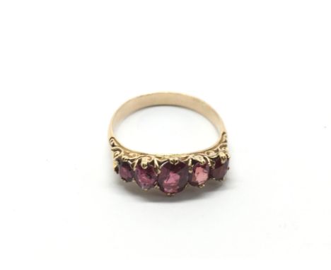 An unmarked gold ring set with five rubies, approx 3.2g and approx size N-O.