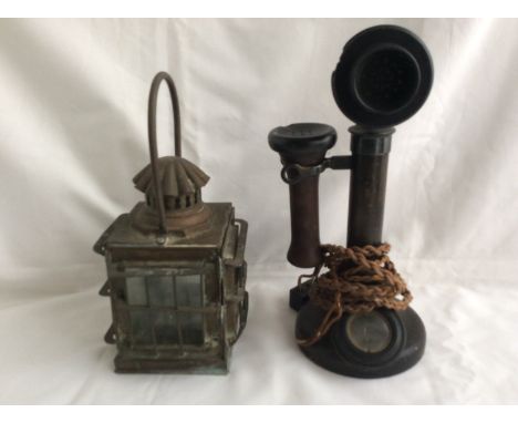 An early Bakelite and metal stick style telephone, plus a small brass carriage lamp.