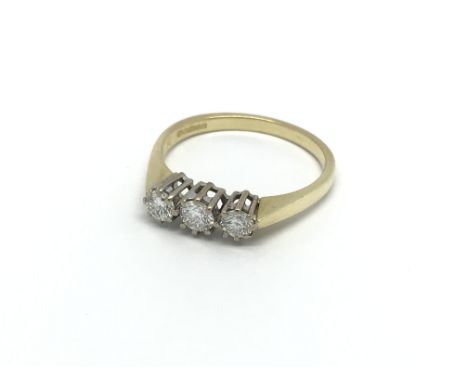 An 18carat gold ring set with a row of three brilliant cut diamonds. Ring size N.