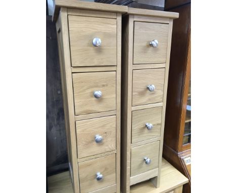 A pair of modern oak flights of drawers each with four drawers