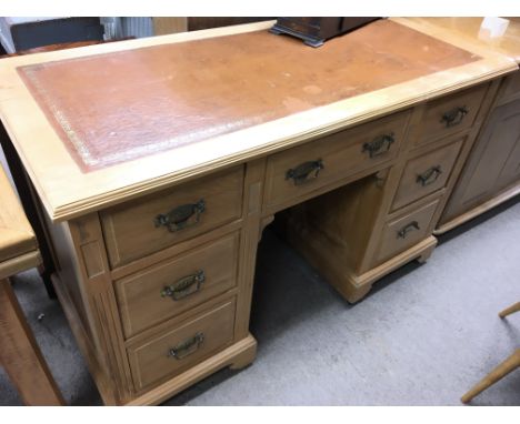 A late Edwardian satin walnut desk with a leather inset top fitted with drawers.