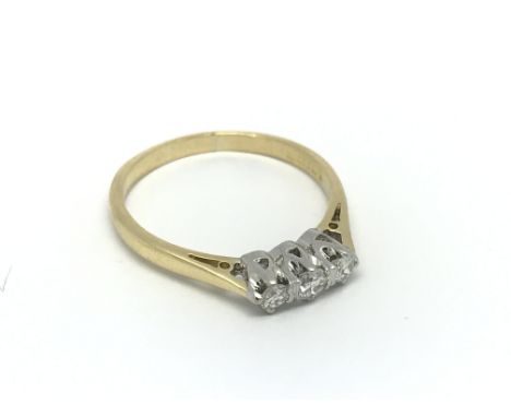 An 18carat gold ring set with a row of three brilliant diamonds. ring size P.