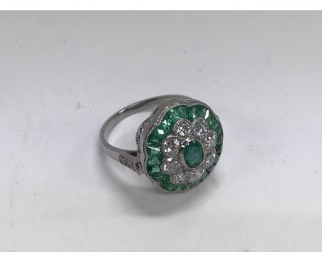 A platinum emerald and diamond floral style dress ring set with a central oval cut emerald, diamond approx 1.15ct, Emeralds a