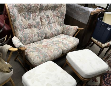 An Ercol two seater sofa with floral drop in cushions and a pair of conforming Ercol stool with detachable cream floral uphol