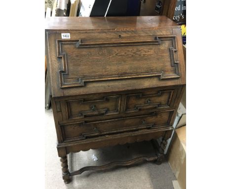 An oak bureau with a hinged full front above two drawers on barley twist legs - NO RESERVE