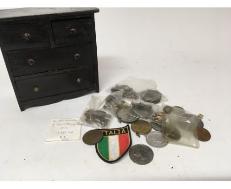 A miniature chest of drawers containing a collection of Victorian and later commemorative medals badges and other oddments (a