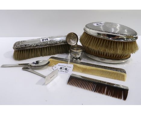 A lot comprising a pair of silver backed hair brushes, a comb, a silver spoon and pusher &amp; a silver urn shaped etui assor