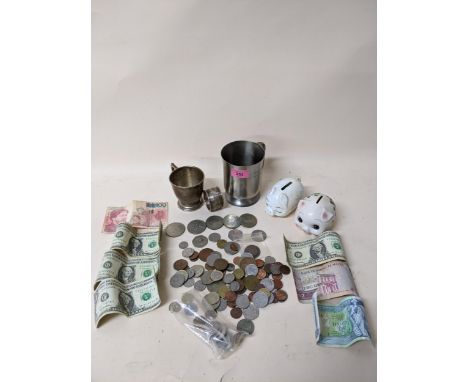 A lot to include commemorative and world coins and banknotes, a 1930's silver Christening mug, napkin ring, two ceramic pig m