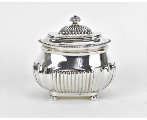 An Edwardian silver tea caddy by Charles Stuart Harris, London 1902, with gadrooned rim, fluted finial, on a part fluted oval