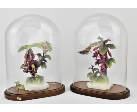 A pair of Royal Worcester models of Ruby-throated hummingbirds on fuchsias by James Alder, one with nest, each on white plint