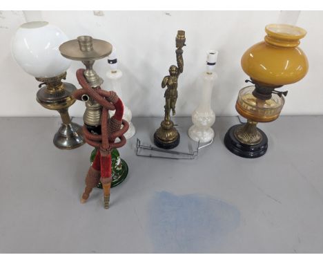 A group of lamps to include two brass oil lamps with glass shades, a brass lamp in the form of a figure and a pair of lamps, 