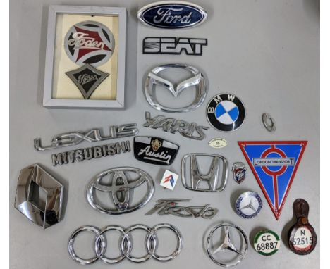 A collection of car badges to include BWM Mercedes, Ford, Austin and others along with a reproduction London Transport enamel