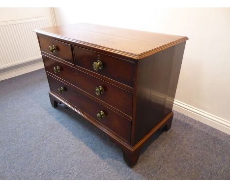 A late 18th century mahogany chest; moulded top, two half-width and two full-width drawers with large circular brass handles,