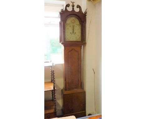 An early 19th century oak-cased and mahogany cross-banded eight-day longcase clock; the broken swan-neck pediment surmounted 