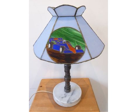 An unusual table lamp modelled from a racing car engine part; the hexagonal Tiffany-style glass frame decorated with a modern