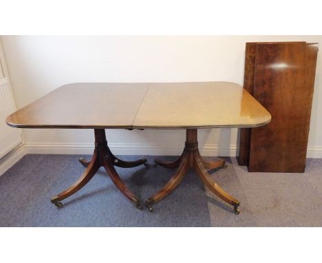 A good Regency-style extending mahogany dining table having two extra leaves; the reeded edge top above turned turned twin pi