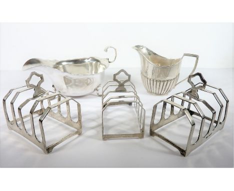 Three hallmarked silver, four-division toast racks; together with a Georgian-style silver sauce boat and a cream jug with ree