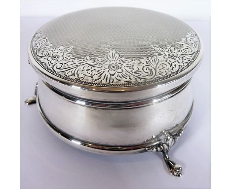 A hallmarked silver and velvet-lined circular jewellery box; flip-up lid with engine-turned and engraved foliate decoration, 