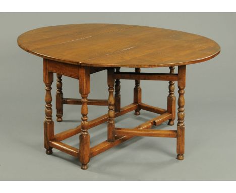 A George III style mahogany oval oak gate leg dining table, raised on turned legs with lobed stretchers.  Width 22 cm, length