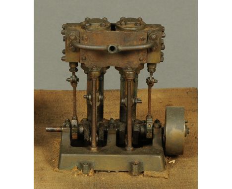 An early vertical Stuart twin cylinder steam engine, with four pistons, 5 cm fly wheel, wooden plinth.