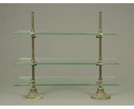 A Victorian three tier free standing table shelf unit, with rectangular glass shelves with centre metal supports with cast ir