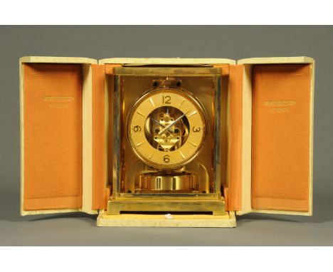 A Jaeger Lecoultre Atmos clock, Serial No. 77337.  Case 22 cm x 18 cm x 30.5 cm, with outer case and note "This clock was ful