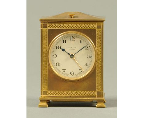 A Zenith brass eight day alarm clock, with engine turned case and silvered dial.  Height 9 cm.  CONDITION REPORT: The clock i
