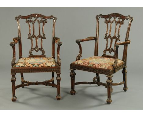 A pair of late 19th/early 20th century Chinese Chippendale style mahogany armchairs, with well carved backs, scroll arms, bli